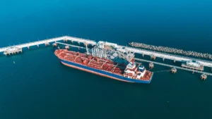 Aerial view of a tanker docked at oil port facilities for cargo transfer.