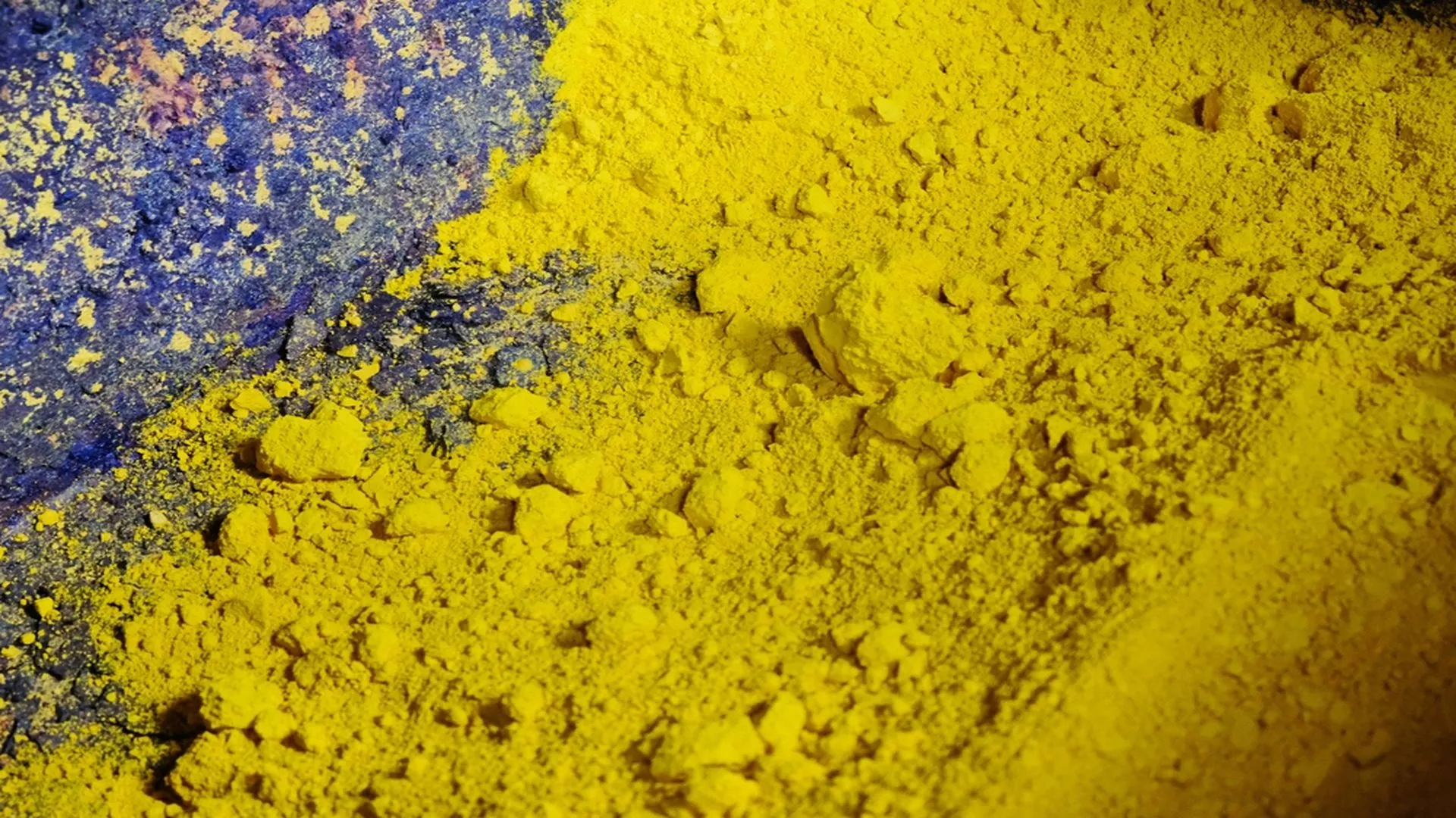 Polvo amarillo brillante de "yellowcake" (óxido de uranio) contenido en un recipiente industrial.