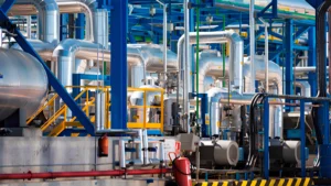 Industrial plant with metal pipes and blue structures in the petrochemical sector where NDT is applied for inspection and control.