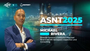 Michael Rivera, posa frente a una planta industrial iluminada, con el logotipo de ASNT 2025 e Inspenet al fondo, durante su participación en la conferencia ASNT 2025.