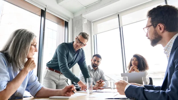Equipo de profesionales en una reunión analizando decisiones operativas y de gestión de la integridad dentro de una organización.