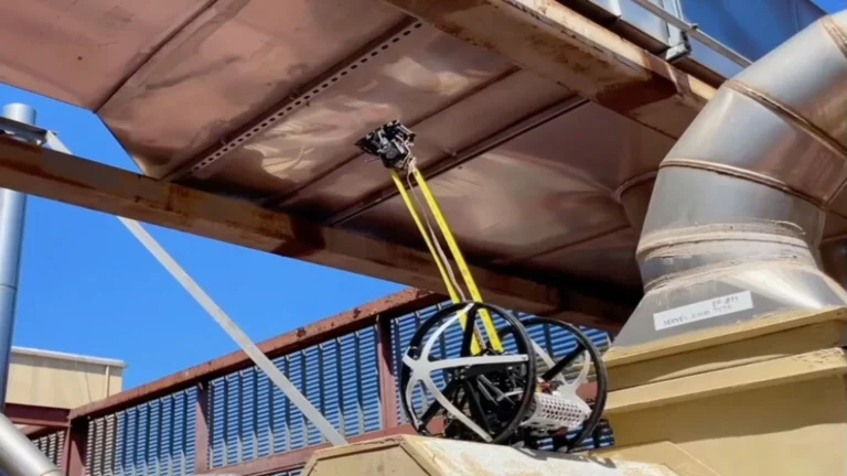 Robot escalador que utiliza una cinta métrica para moverse