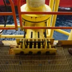 Estructura de un riser offshore en plataforma marina durante una inspección de risers, mostrando el soporte y sujeción del conducto sobre la cubierta.