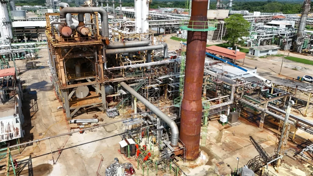 Vista aérea de una planta industrial de azufre, con estructuras metálicas, chimeneas, sistemas de tuberías y andamiaje para trabajos de rehabilitación.