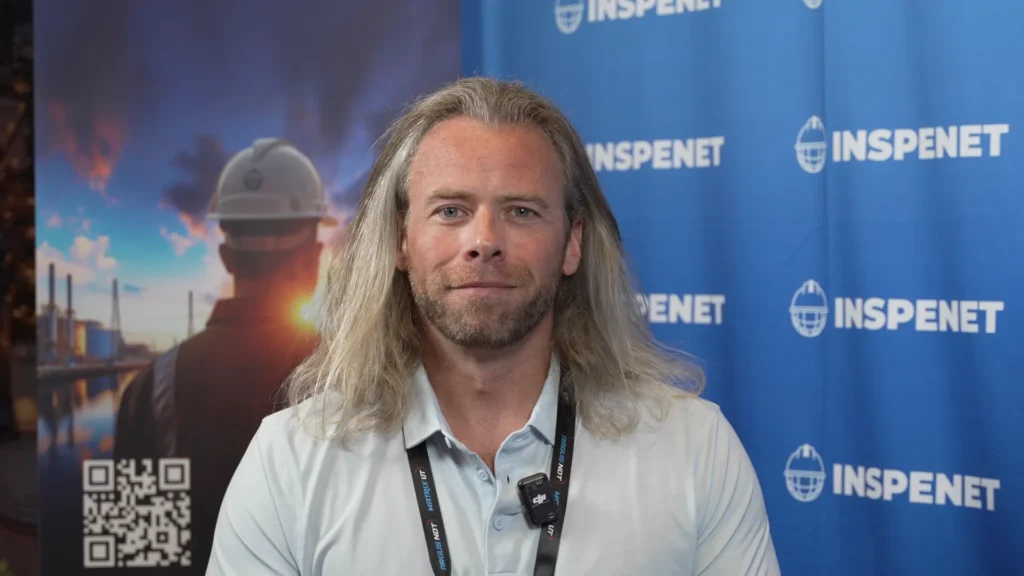 Joshua de Monbrun frente al stand de Inspenet durante una entrevista sobre ensayos no destructivos.