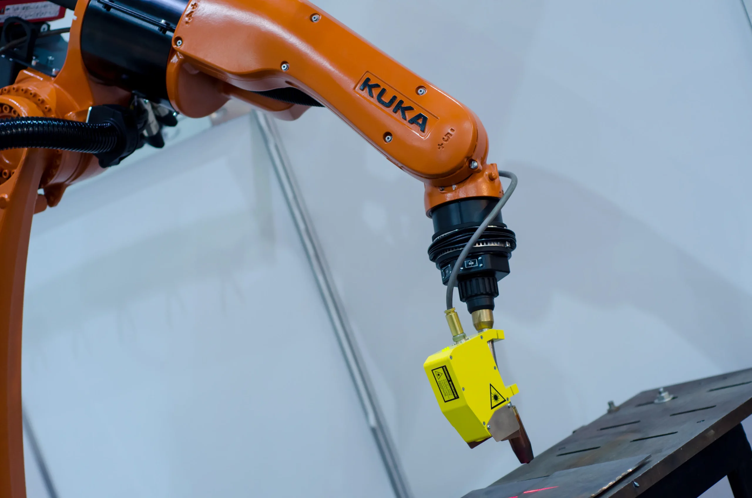 Robot industrial KUKA promoviendo la soldadura automatizada en proceso de fabricación avanzada.
