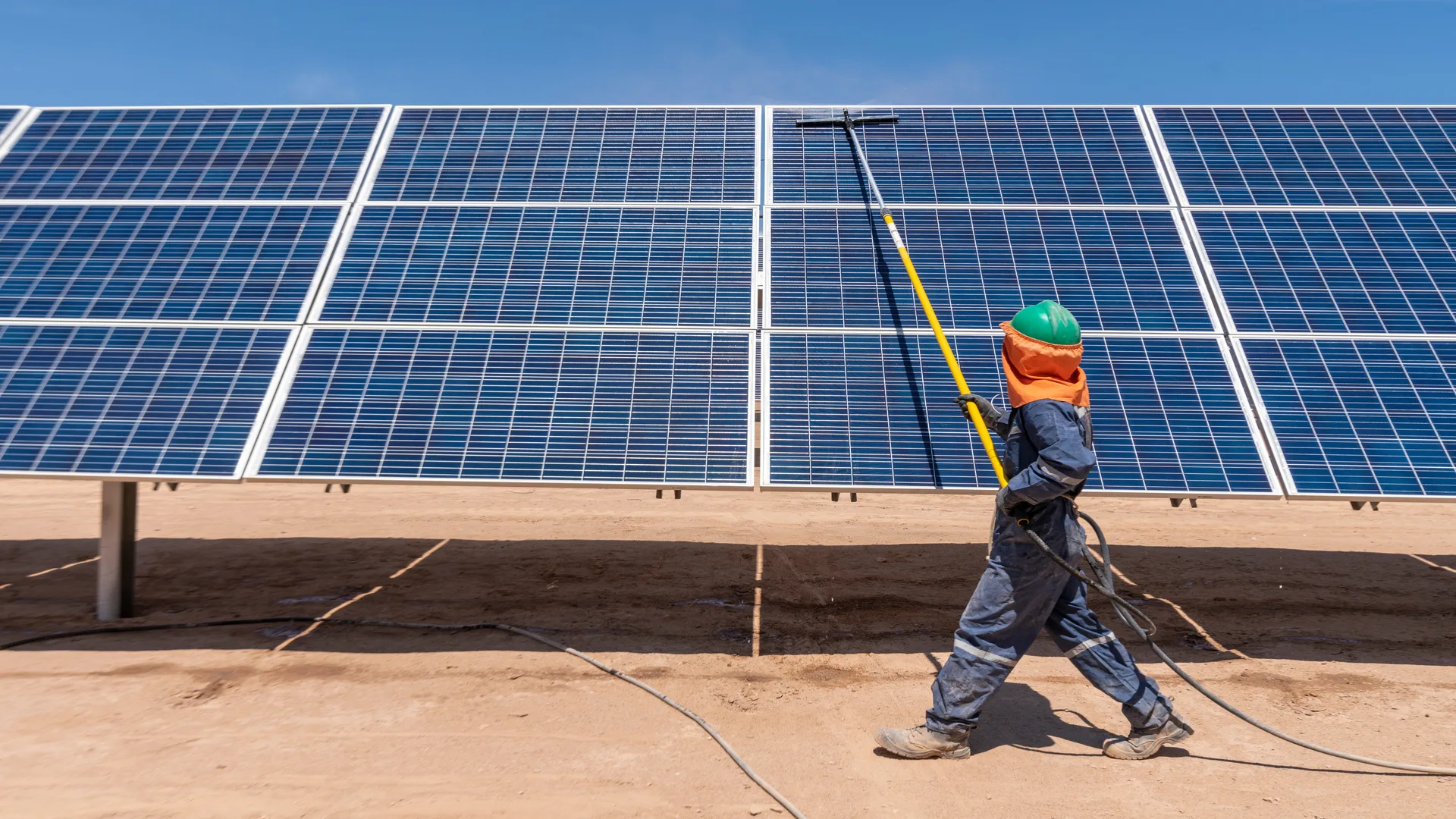 Trabajador realiza mantenimiento en paneles solares mientras el aumento del precio del aluminum impacta los costos de la industria solar en Estados Unidos.