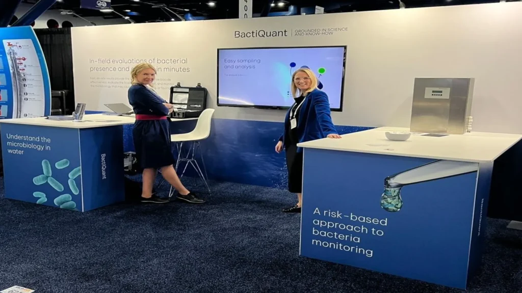 BactiQuant representatives presenting their bacterial detection solutions at an industry trade show, highlighting mobile and in-line meters.