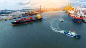 Buques portacontenedores operando en un terminal marítimo con grúas y carga de mercancías durante la transición energética.