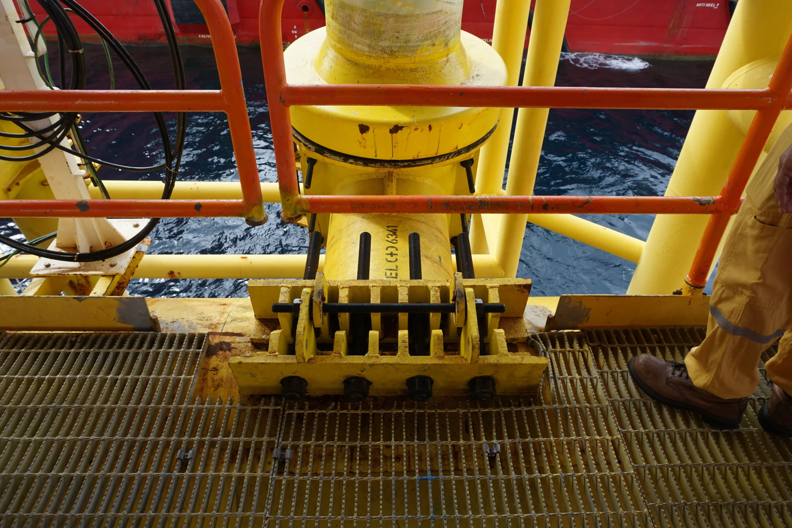 Structure of an offshore riser on a marine platform during risers inspection, showing the support and securing of the conduit on the deck.