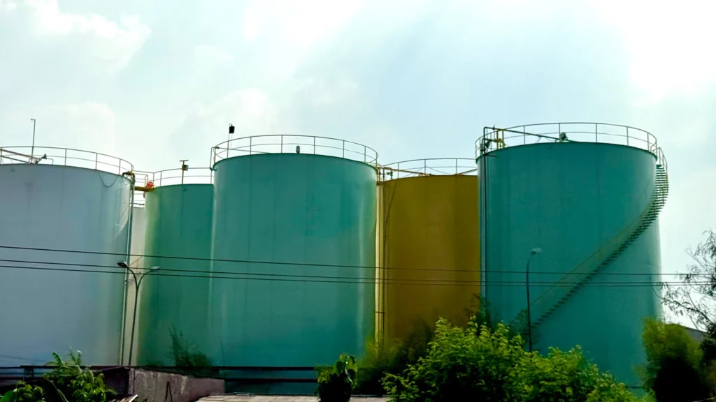Tanques de almacenamiento sobre el suelo industriales, que ilustran los activos cuya inspección es vital, incluyendo los tanques de fibra de vidrio.