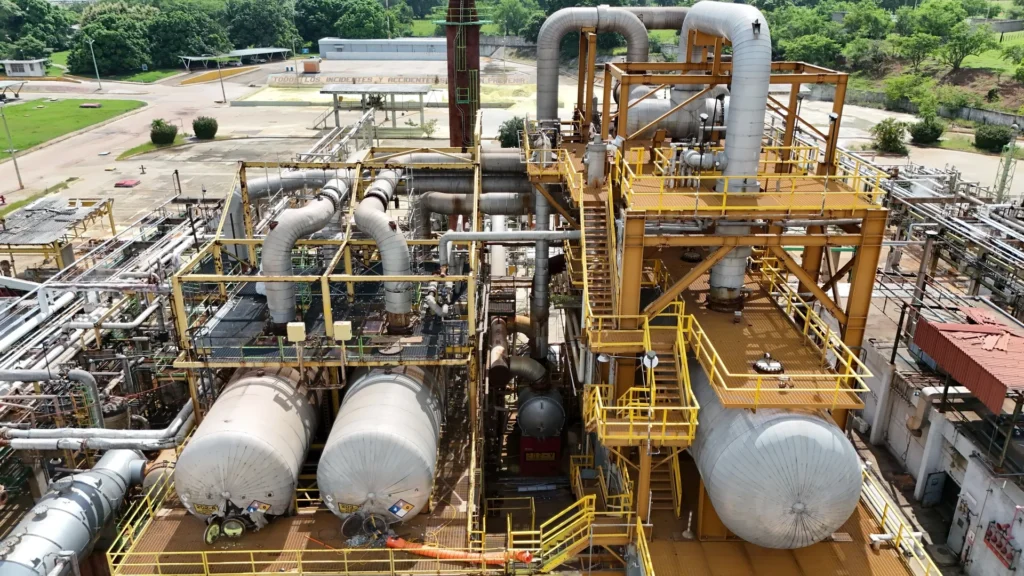 Aerial view of a sulfur processing plant with complex industrial infrastructure, including reactors, exchangers and pipelines.