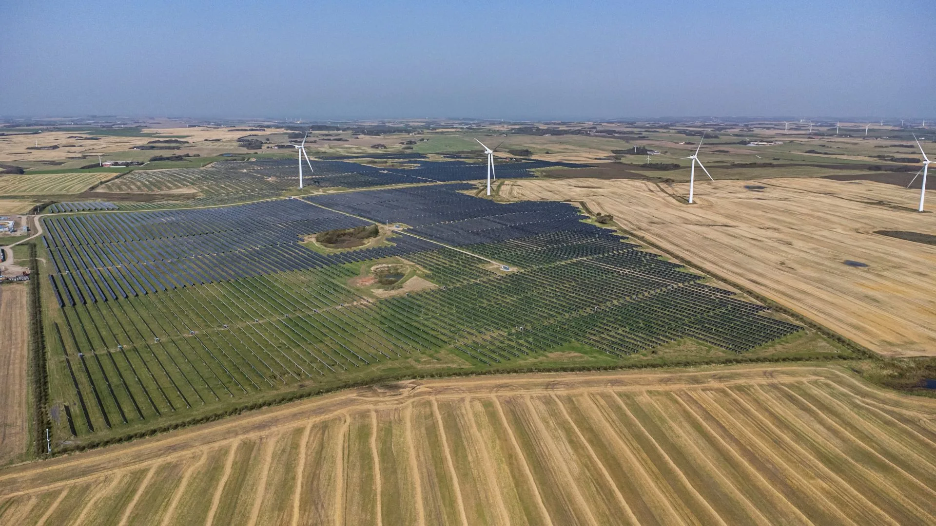 Parque solar y aerogeneradores que respaldan el electricity supply con energía renovable.