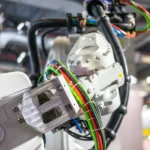 Un brazo de Robotic automation realiza tareas de manipulación de cables, una de las aplicaciones evaluadas en el Industrial Dexterity Benchmark para mejorar la precisión mediante inteligencia artificial.
