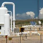Planta terrestre con infraestructura de compresión de gas y sistemas de tuberías industriales.