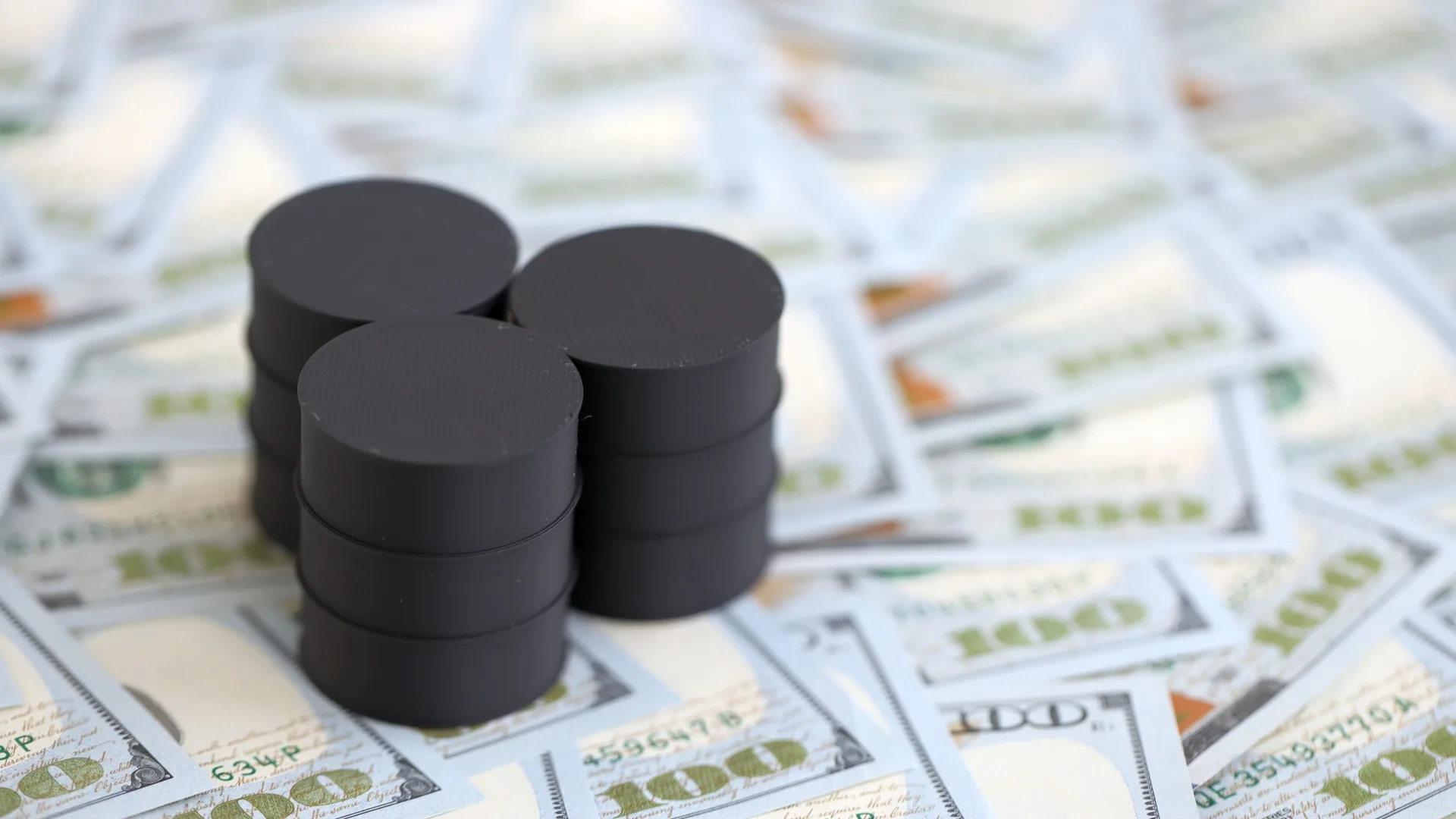 Barriles de petróleo sobre billetes de 100 dólares